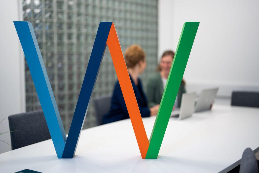 Mitarbeiter diskutieren die Vorteile künstlicher Intelligenz bei der Analyse von Umfragen. KI hilft dabei, Antworten zu gruppieren, Emotionen zu erkennen und klare Zusammenfassungen des Feedbacks zu erstellen.
